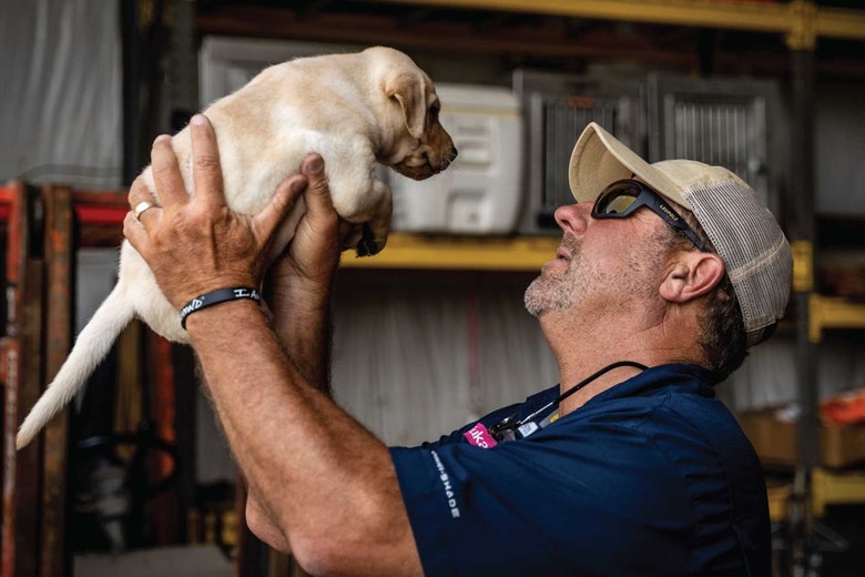 /au/sites/g/files/fnmzdf6461/files/2024-08/us-esd-eukanuba-pro-trainer-chris-akin-holds-a-lab-puppy.jpeg