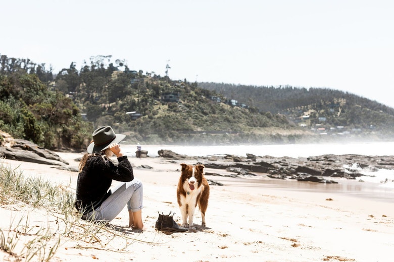 /au/sites/g/files/fnmzdf6461/files/2024-10/woman-with-dog-on-beach.jpeg